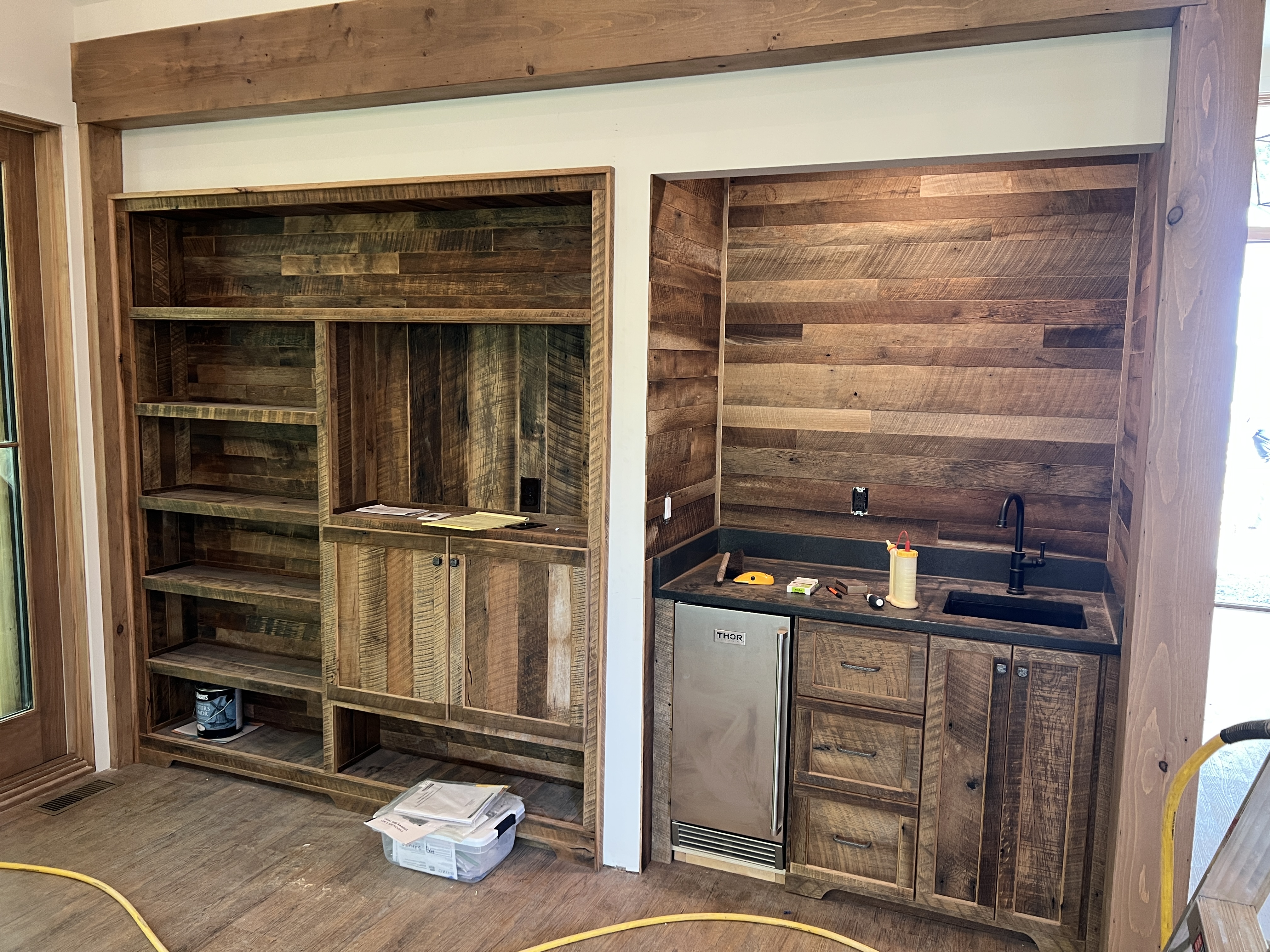 Reclaimed wood built-in wall unit from alternate angle showing windows