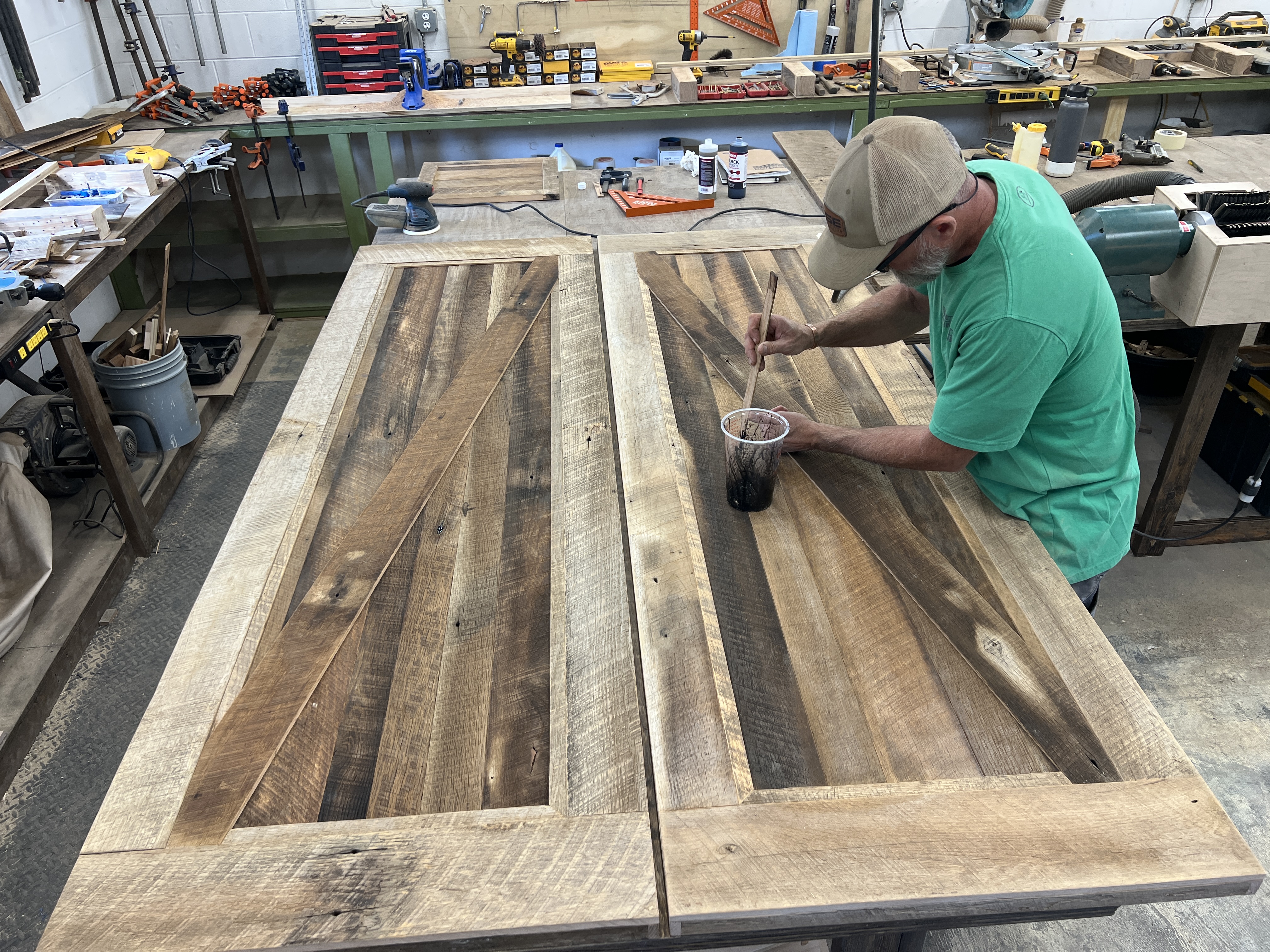 Jeff Cairnes finishing reclaimed wood table tops in the Legacy Woodcraft shop